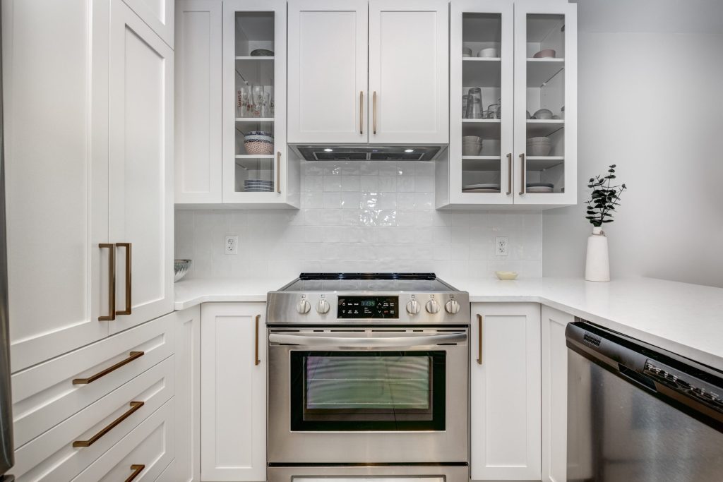 An electric slide-in range and a dishwasher in a white American kitchen